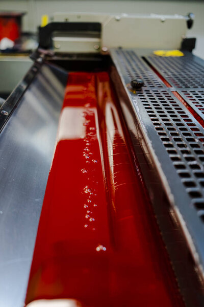 Цветные и глянцевые ролики офсетной печатной машины. смещение цвета чернил. Маджента. Фотография сделана вертикально, на лицевой стороне фотографии с выбранным фокусом.