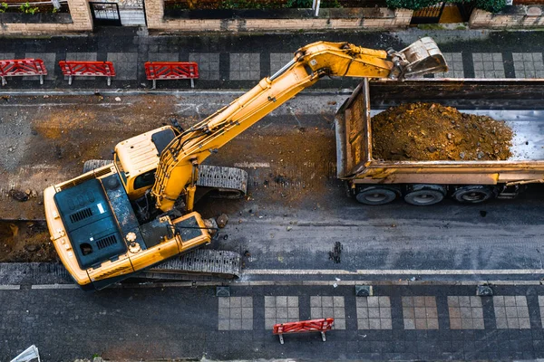 建設機械は都市道路を掘削して排水インフラを改善します トップビュー 選択的フォーカスマシン — ストック写真