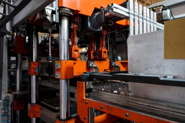 Vacuum thermoforming machine in the factory,Vacuum thermoforming machine is used for producing plastic packaging. Close-up of the machine making a mold. Selective focus front