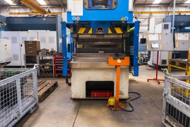 Düz metal levha için hidrolik fren ya da bükme makinesi. Bükme makinesindeki işçi bükme levhası metali.