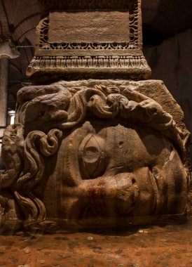 Yerebatan - Basilica Sarnıç 'taki Medusa üssüne ters çevrilmiş sütun. Seçici odak medusa başı.