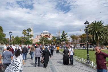 İstanbul, Türkiye - 27-09-2022: Bulutlu bir günde Sultanahmet Meydanı 'ndan Ayasofya' ya yürüyen insanlar. Arka planda Ayasofya Camii.