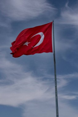 Gökyüzünde bulut, dalgalanan Türk bayrağı. Bayrak direği ve kumaş bayrağı.