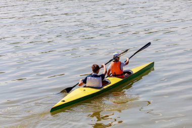 Kürekli iki kız nehirdeki bir kanoda senkronize kürek çekiyorlar. Metin için kopyalama alanı olan arkaplan. Amatör rafting.