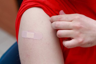 Coronavirus aşısından sonra hastaların omzunda mühürlü alçı var. Gerçek prosedür ve durum. Seçici odak