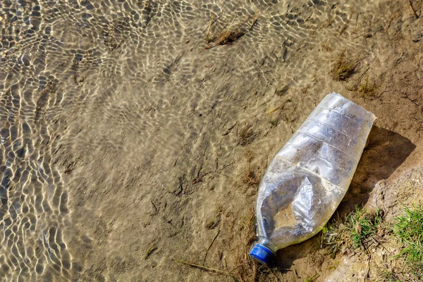 Bottles discarded in nature. Environmental pollution with plastic waste. Hazardous and toxic waste. Ecological disaster of the planet. Causes of climate change. Background with copy space for text