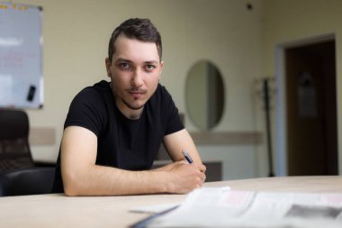 İş yerindeki ciddi genç adam ya da yetişkin adam ofisin bulanık geçmişine direkt olarak bakar.