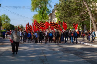 Tören alayındaki insanlar. İkinci Dünya Savaşı anısına zafer yürüyüşü. 9 Mayıs 2021 Balti Moldova. İllüstrasyon Editörü