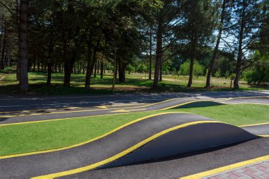 Şehir parkında slaytlı bisiklet yolu elemanı. Bisikletler ve kaykaylar için patika. Patenler için sıra dışı bir yol. Kentsel bir çevrede kaykay parkı. Arkaplan