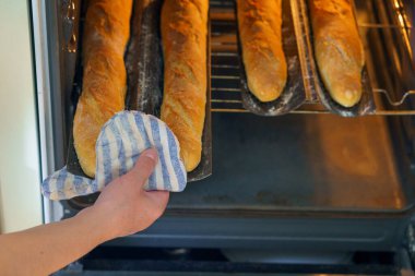 Hamur fırında. Fırın tepsisinde Fransız ekmeği. Ev yapımı ekmek. Seçici odaklı arkaplan ve metin için alanı kopyala.