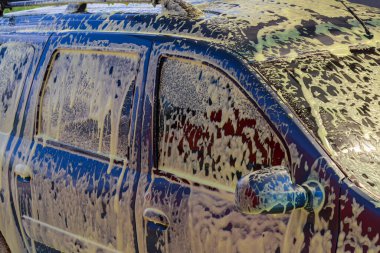 Modern bir araba yıkamada köpüklü bir araba metin ya da yazı için fotokopi alanı olan bir arka plan. İllüstrasyon başyazısı. 23 Temmuz 2021, Balti Moldova.