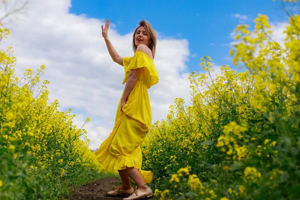 Sarı Elbiseli Parlak Sarı Arka Planda Çiçek Açan Kolza Tohumu — Stok fotoğraf