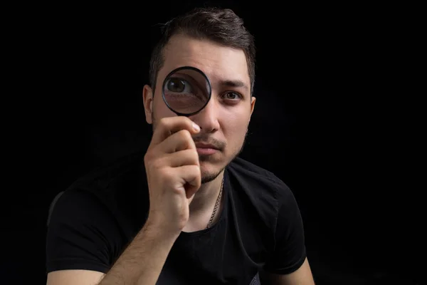 Homem Bonito Jovem Uma Lupa Sobre Fundo Preto Baixo Símbolo — Fotografia de Stock