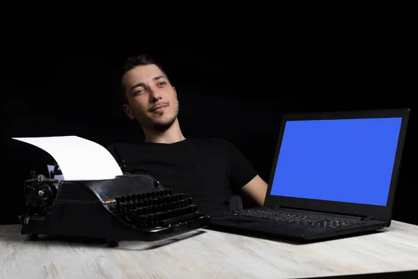 Mladý Pohledný Muž Uprostřed Mezi Psacím Strojem Laptopem Černém Pozadí — Stock fotografie