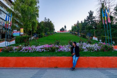 Şehir merkezinde Kotovsky anıtı olan bir turist. Metin veya yazıtlar için kopyalama alanı olan bir arkaplan. 5 Eylül 2021 Hincesti Moldova.