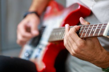 Gitar, müzisyen bir gitaristin elinde odak dışı. Metin veya harf için kopyalama alanı olan bir arkaplan. Seçici odak