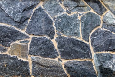 Vahşi bir dekoratif taşın pürüzlü yüzeyi. Dokulu arka plan. Tasarım için boş. Altında ya da altında. Metin için alanı kopyala