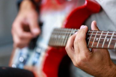 Gitar, müzisyen bir gitaristin elinde odak dışı. Metin veya harf için kopyalama alanı olan bir arkaplan. Seçici odak