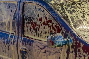 Modern bir araba yıkamada köpüklü bir araba metin ya da yazı için fotokopi alanı olan bir arka plan. İllüstrasyon başyazısı. 23 Temmuz 2021, Balti Moldova.