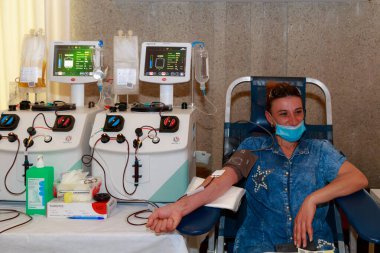 Gönüllüler kan bağışı yapar. Kan bağışı günü için halka açık bir etkinlik. Metin veya harf için kopyalama alanı olan bir arkaplan. İllüstrasyon başyazısı. 13 Haziran 2021, Balti Moldova.
