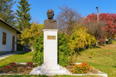 Alexandru Donici. 19. yüzyılın Moldovalı çevirmen ve yazarının anıtı, ailesinin evinin arka planına karşı. İllüstrasyon başyazısı. 20 Ekim 2021 Donici Köyü, Moldova.