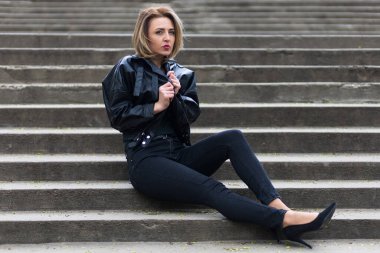 Şehir ortamında, şehir merdivenlerinde siyah elbiseli bir kadının portresi. Özgür ve bağımsız kadın kavramı