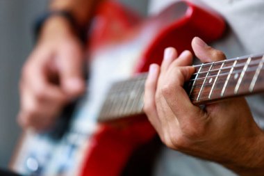 Gitar, müzisyen bir gitaristin elinde odak dışı. Metin veya harf için kopyalama alanı olan bir arkaplan. Seçici odak