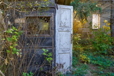 Pencereleri ve açık ahşap kapısı olan eski bir ahır. Metin için kopyalama alanı olan arkaplan