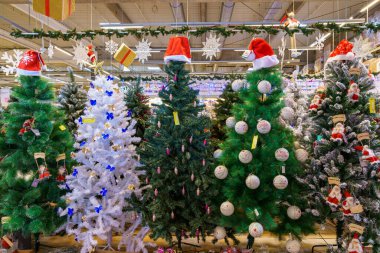 Yapay Noel ağaçları ve mağazadaki yeni yılın sembolleri. Metin için kopyalama alanı olan arkaplan. İllüstrasyon başyazısı. 18 Aralık 2021 Balti Moldova.