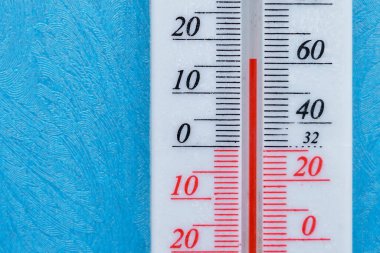 Ortam sıcaklığını ölçmek için termometre. Metin veya harfler için kopyalama alanı olan sembolik soğuk mavi arkaplan. Evdeki ve sokaktaki soğuk kavramı.