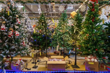 Yapay Noel ağaçları ve mağazadaki yeni yılın sembolleri. Metin için kopyalama alanı olan arkaplan. İllüstrasyon başyazısı. 18 Aralık 2021 Balti Moldova.