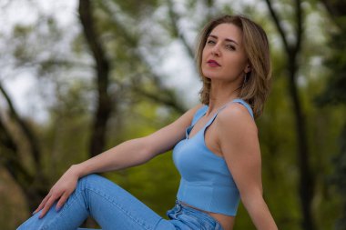 Park ya da ormanın bulanık yeşil arka planında mutlu ve özgür bir kadının portresi. Metin veya harf için kopyalama alanı olan arkaplan