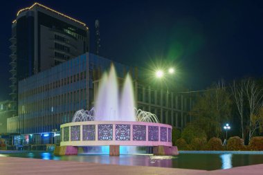 Central City çeşmesi gece aydınlandı. Şehrin en tanınan turistik manzarası. Metin için kopyalama alanı olan arkaplan. İllüstrasyon başyazısı. 22 Ekim 2021 Balti Moldova.