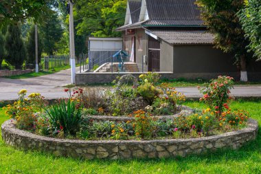 Şehrin kentsel ortamında çok güzel bir çiçek tarhı. Manzara tasarımında çiçekler ve yeşillik. Metin veya yazıtlar için kopyalama alanı olan arkaplan.