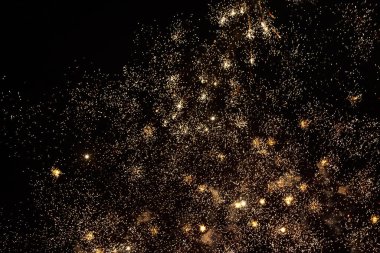 Havai fişekler, metin veya yazıtlar için kopyalama alanı olan karanlık bir gökyüzü zemininde kıvılcımlar saçar. Tasarım için grafik bir kaynak. Tasarımcı için boş. Altını çiz ya da altını.