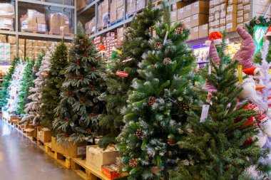 Yapay Noel ağaçları ve mağazadaki yeni yılın sembolleri. Metin için kopyalama alanı olan arkaplan. İllüstrasyon başyazısı. 18 Aralık 2021 Balti Moldova.