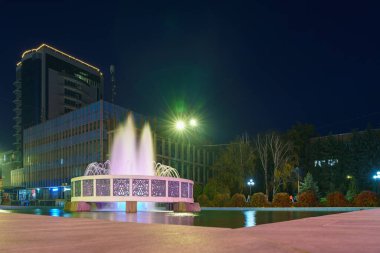 Central City çeşmesi gece aydınlandı. Şehrin en tanınan turistik manzarası. Metin için kopyalama alanı olan arkaplan. İllüstrasyon başyazısı. 22 Ekim 2021 Balti Moldova.
