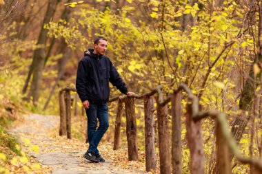 Genç bir adam altın sonbahar boyunca vahşi hayatın tadını çıkarır. Metin veya yazıtlar için kopyalama alanı olan bir arkaplan. Doğayla baş başa kalma kavramı.