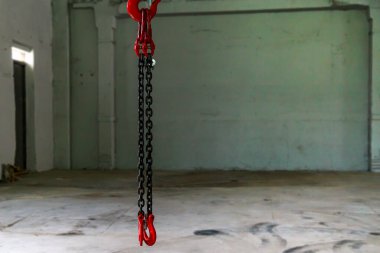 Endüstriyel bir hangarın bulanık arka planında zincirli bir kanca. Metin için kopyalama alanı olan arkaplan