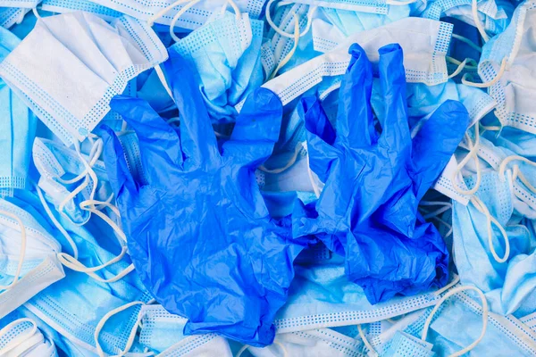 Used disposable medical masks and gloves background. Medical waste. Garbage and the environmental impact of the covid-19 coronavirus pandemic. Ecology concept.