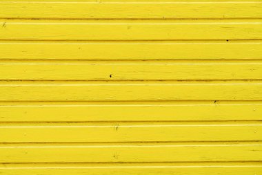 Rough textured painted wood surface of parallel horizontal yellow planks. Background or graphic resource for design