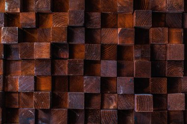 Rough textured volumetric surface of an old retro vintage wall made of square blocks of wood of different sizes. Background or graphic resource for design