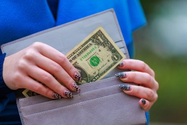 Bir kadının eli cüzdanından 100 dolarlık banknot çıkarır. Metin veya yazıtlar için kopyalama alanı olan arkaplan.