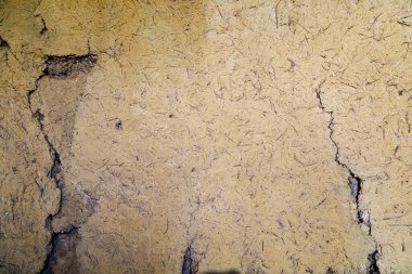 Rough textured surface of a wall made of clay or adobe, background. Backdrop or graphic resource for design. Eco tourism and village recreation concept