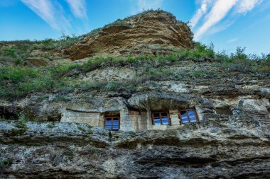 Keşişler için hücreleri olan Rocky Manastırı. Metin için kopyalama alanı olan arkaplan