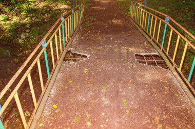 An old crumbling concrete footbridge across the river. Background with copy space for text