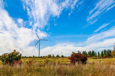 Elektrik üretimi için yel değirmenleri. Yeşil enerji konsepti. Metin için kopyalama alanı olan arkaplan. Şehrin dışındaki modern çiftlik..