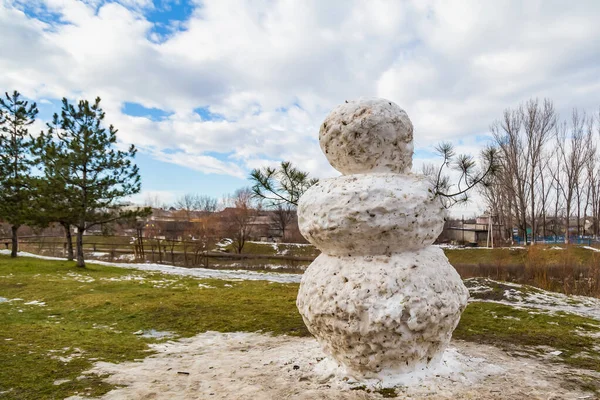 一个巨大的春天雪人在融化的草地上 背景色 带有字母或文字的复制空间 — 图库照片