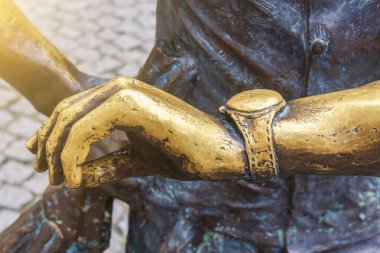 Elinde bronz heykel saati elementi var. Gecikme ve bekleme konsepti. Metin ve seçici odak için kopyalama alanı olan arkaplan