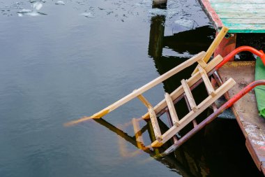 Nehir kıyısındaki iskelede tahta merdivenler ya da su deposu. Geleneksel dini bayram vaftiz töreni ve çukurda yüzme. Metin için kopyalama alanı olan arkaplan